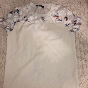 White top with floral design on sleeves